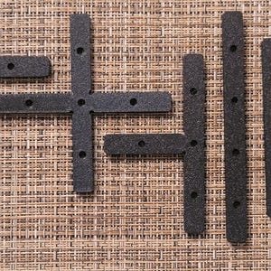 May include: A set of black plastic corner brackets, including a T-shaped bracket and several straight brackets. The brackets have multiple holes for attaching screws.