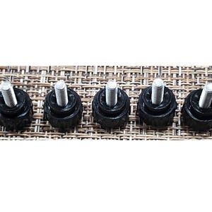 May include: Five black plastic furniture feet with silver screws. The feet are round and have a threaded screw in the center.
