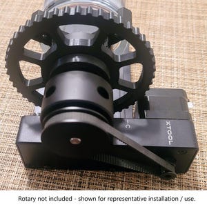 May include: A black rotary tool with a belt drive system and a gear. The tool is labeled "XTOOL" and has a black plastic housing.