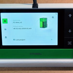 May include: A white and green 3D printer with a touchscreen display showing the device name "F1 Ultra_v2" and firmware version "40.52.012.2020.01.h15".
