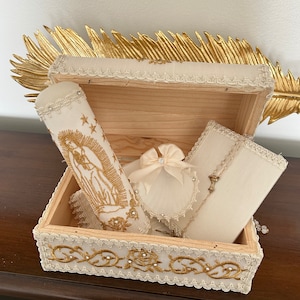 wooden box adorned with the Virgen Maria holds an equally exquisite baptism candle set.