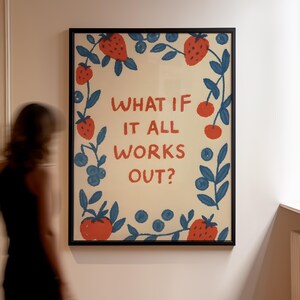 K&ouml;nnte beinhalten: Ein gerahmter Kunstdruck mit dem Text "WHAT IF IT ALL WORKS OUT?" in Rot. Der Druck ist mit roten Erdbeeren, Blaubeeren und blauen Bl&auml;ttern auf cremefarbenem Hintergrund verziert. Der Rahmen ist schwarz.