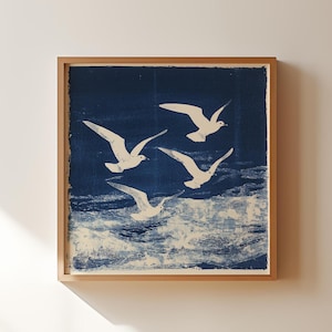 May include: A framed print of four white seagulls flying over a blue ocean. The print is on a blue background and has a white border.