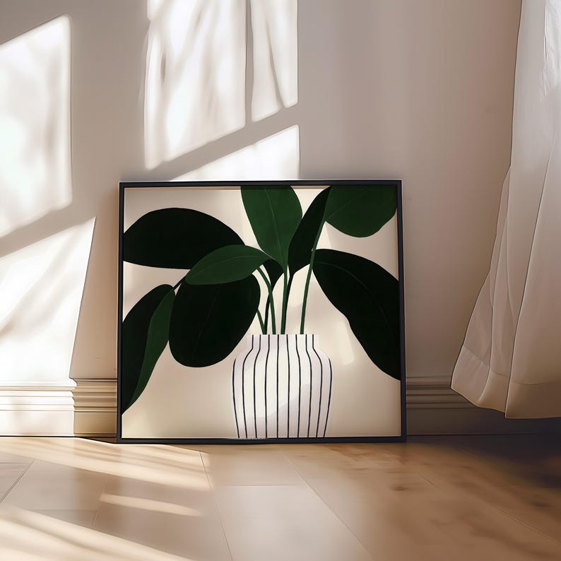 May include: A framed art print featuring a stylized illustration of a potted plant. The plant has large, dark green leaves and is in a white vase with vertical black stripes. The artwork is set against a neutral background.