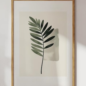 Könnte beinhalten: Ein gerahmter Druck eines minimalistischen Aquarellbildes eines einzelnen grünen Blattes auf weißem Hintergrund.