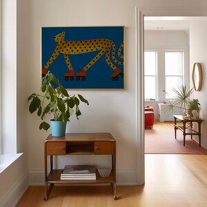 May include: A framed art print of a cheetah on roller skates, set against a blue backdrop. The cheetah is yellow with black spots and orange roller skates. The artwork hangs above a wooden side table, with a plant in a blue pot.