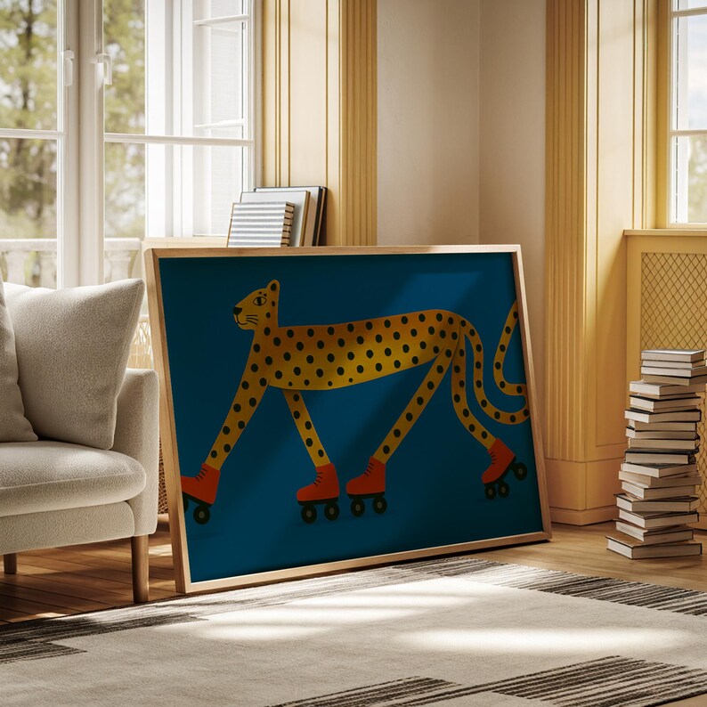 May include: A framed art print depicting a yellow cheetah with black spots, wearing orange roller skates, on a teal background. The cheetah illustration has a playful, cartoon style. The frame is a light wood colour.