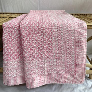 May include: A pink and white kantha quilt with a floral pattern. The quilt is made of cotton and is hand-stitched.