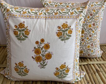 May include: Two white cotton pillowcases with a floral print in shades of yellow and green. The pillowcases have a border with a repeating pattern of small flowers.