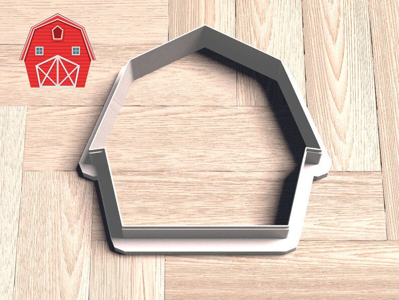 May include: A white plastic cookie cutter shaped like a barn with a simple design. The cutter is on a wood surface.