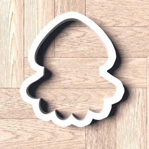 May include: White plastic cookie cutter shaped like an octopus with eight tentacles.