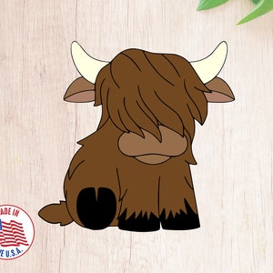 May include: A cartoon illustration of a brown Highland cow with long hair covering its face. The cow is sitting with its legs tucked under its body. The cow has black hooves and a white nose.