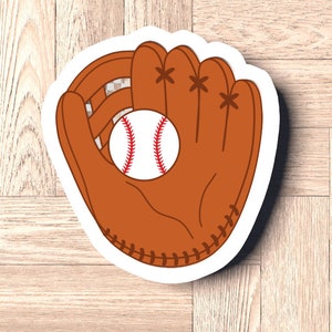 May include: A brown leather baseball glove with white stitching, holding a white baseball with red stitching.