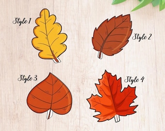 Può includere: Quattro stili diversi di foglie autunnali, ognuna con una forma e un colore unici. Lo stile 1 è una foglia di quercia gialla, lo stile 2 è una foglia marrone, lo stile 3 è una foglia arancione a forma di cuore e lo stile 4 è una foglia di acero rossa.