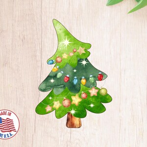 May include: A watercolor illustration of a green Christmas tree with colorful ornaments and lights. The tree is decorated with stars and has a brown trunk.