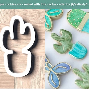 Peut inclure: Un emporte-pièce en plastique blanc en forme de cactus avec un échantillon de biscuits décorés de glaçage vert et bleu. Les biscuits sont décorés d'accents dorés et ont un effet aquarelle. Le texte "@festivelyfrosted" est inclus dans l'image.