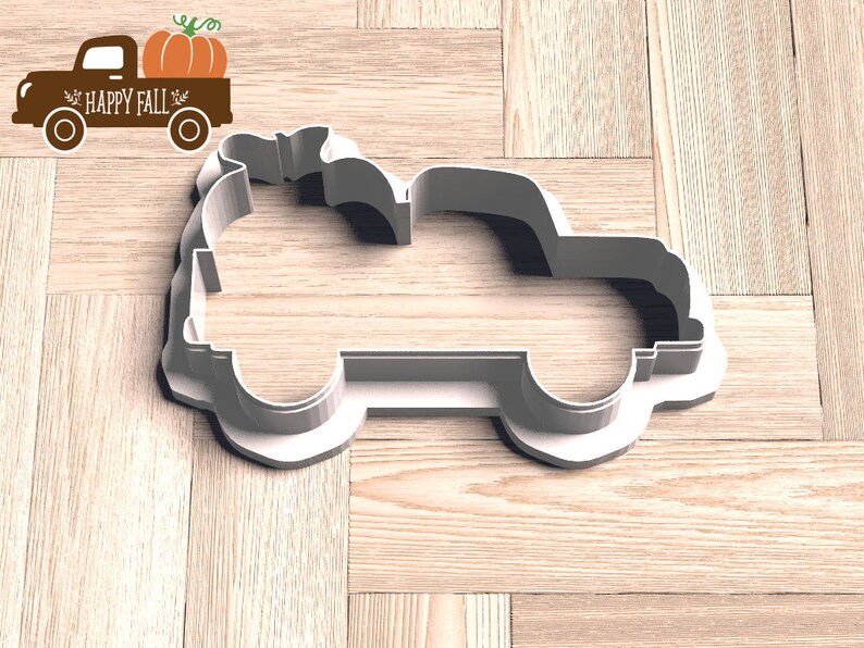 Pu&ograve; includere: Un tagliabiscotti in plastica bianca a forma di camioncino con una zucca nel cassone. Accanto, una grafica marrone di un camion con una zucca e le parole "HAPPY FALL".
