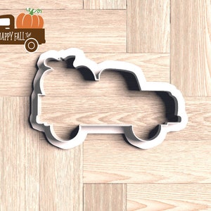 Pu&ograve; includere: Tagliapasta bianco a forma di camion con una zucca sopra. Il camion &egrave; un design a tema autunnale. Un grafico di camion marrone con una zucca e le parole "HAPPY FALL" si trova nell'angolo in alto a sinistra.