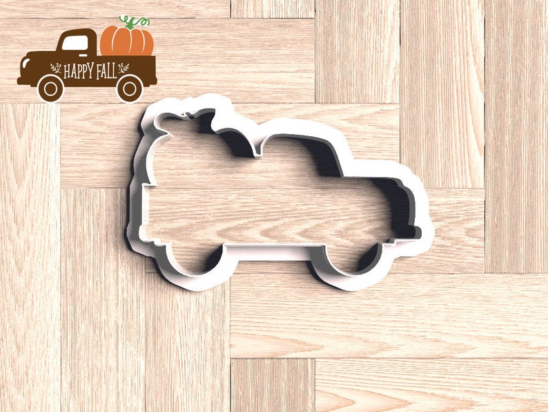 Pu&ograve; includere: Tagliapasta bianco a forma di camion con una zucca sopra. Il camion &egrave; un design a tema autunnale. Un grafico di camion marrone con una zucca e le parole "HAPPY FALL" si trova nell'angolo in alto a sinistra.