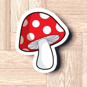 May include: A red and white mushroom sticker with white dots on the cap and a white stem. The sticker has a white outline.
