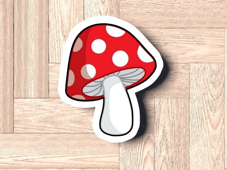 May include: A red and white mushroom sticker with white dots on the cap and a white stem. The sticker has a white outline.