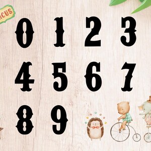 May include: Black and white numbers 0 through 9 in a vintage circus font style. The numbers are arranged in three rows on a light wood background.