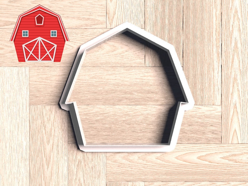 May include: White plastic barn-shaped cookie cutter on a wood background.