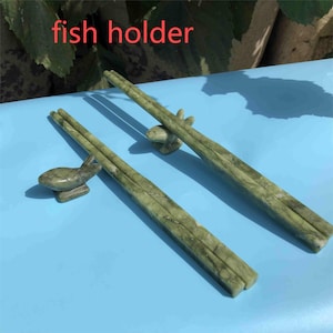 Op de afbeelding: Groene marmeren eetstokjes met bijpassende visvormige eetstokjessteunen. De eetstokjes en steunen hebben een natuurlijk, geaderd patroon. De tekst "fish holder" is zichtbaar.