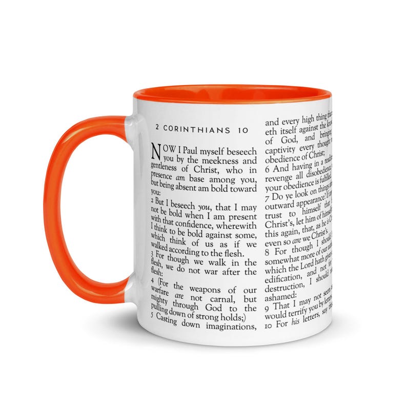 May include: White ceramic mug with an orange interior and handle. The mug features text from 2 Corinthians 10. A religious-themed coffee mug, perfect for enjoying your favorite beverage.