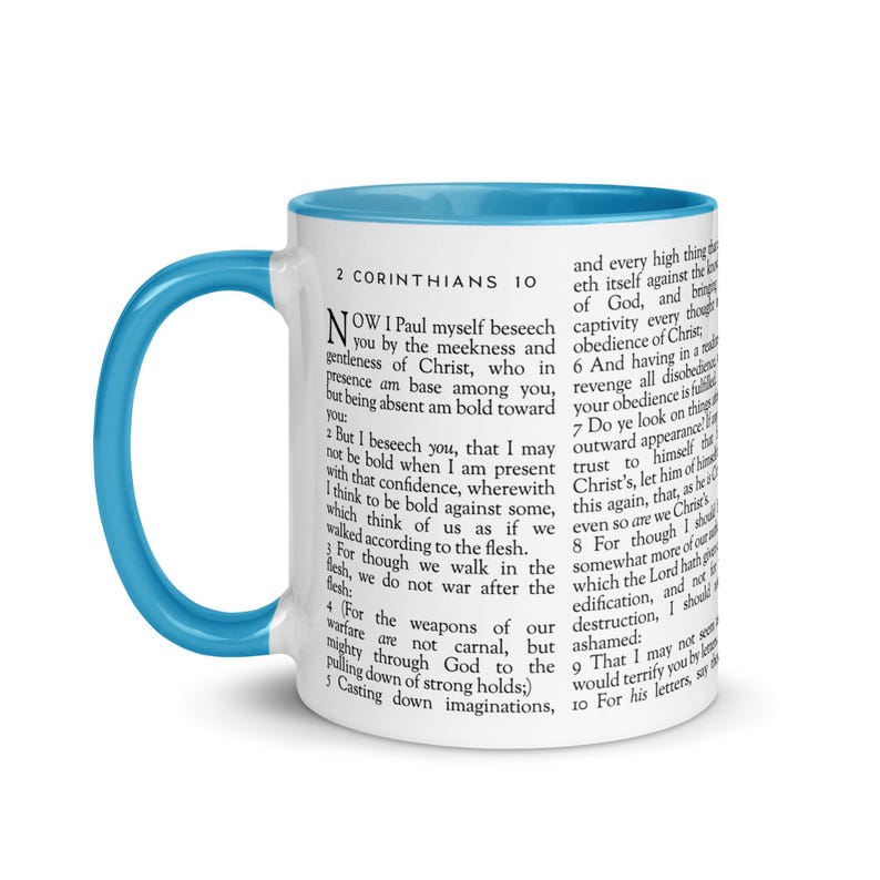 May include: A white ceramic mug with a light blue interior and handle. The mug features text from 2 Corinthians 10. The mug is a standard size for coffee or tea.