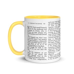 May include: White ceramic mug with a yellow interior and handle. The mug features text from 2 Corinthians 10. The text is in black and is printed on the exterior of the mug. The mug is a standard size.