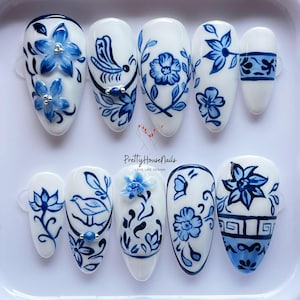 Elegant Blue Floral Nail Art Set, Hand-painted 3D Flowers & Birds, White, Blue Ceramic Design, Unique Almond Nail Set for Special Occasions.