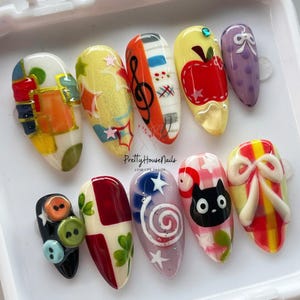 Uñas postizas caprichosas con diseños artísticos: notas musicales, manzana, lazos bonitos, gato negro, uñas kawaii, uñas coloridas, uñas de fantasía, uñas de dibujos animados.