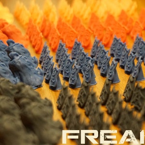 Peut inclure: Une collection de figurines miniatures imprimées en 3D dans différentes couleurs, notamment orange, rouge, bleu et noir. Les figurines sont disposées en rangées sur une surface en bois. Les figurines sont toutes de formes et de tailles différentes, et certaines présentent des détails complexes. Les figurines sont probablement destinées à être utilisées dans un jeu de société ou un jeu de rôle.