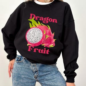 May include: Black sweatshirt with a pink and white dragon fruit graphic and the text "Dragon Fruit" in pink.