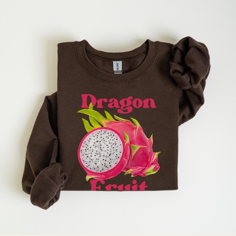 May include: Brown sweatshirt with a pink and white dragon fruit graphic and the text "Dragon Fruit" in pink.