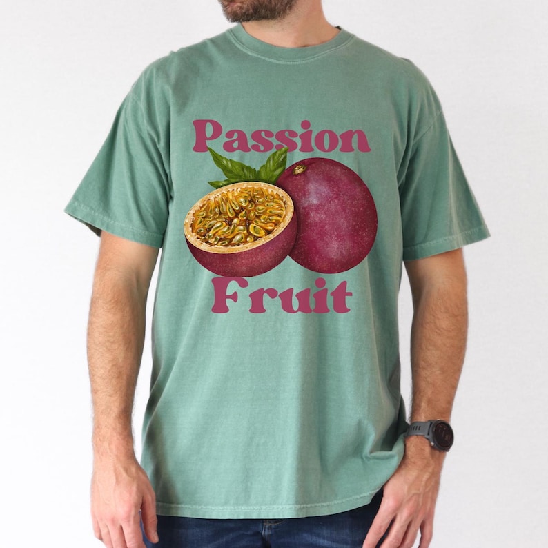May include: A teal green t-shirt with a graphic of a passion fruit and the text "Passion Fruit" in pink.