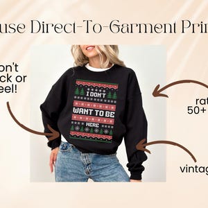 K&ouml;nnte beinhalten: Schwarzes Sweatshirt mit einem festlichen Design mit der Aufschrift "I DON'T WANT TO BE HERE". Das Design umfasst Weihnachtsb&auml;ume und Schneeflocken. Das Sweatshirt ist f&uuml;r &uuml;ber 50 W&auml;schen ausgelegt und hat einen Vintage-Look.