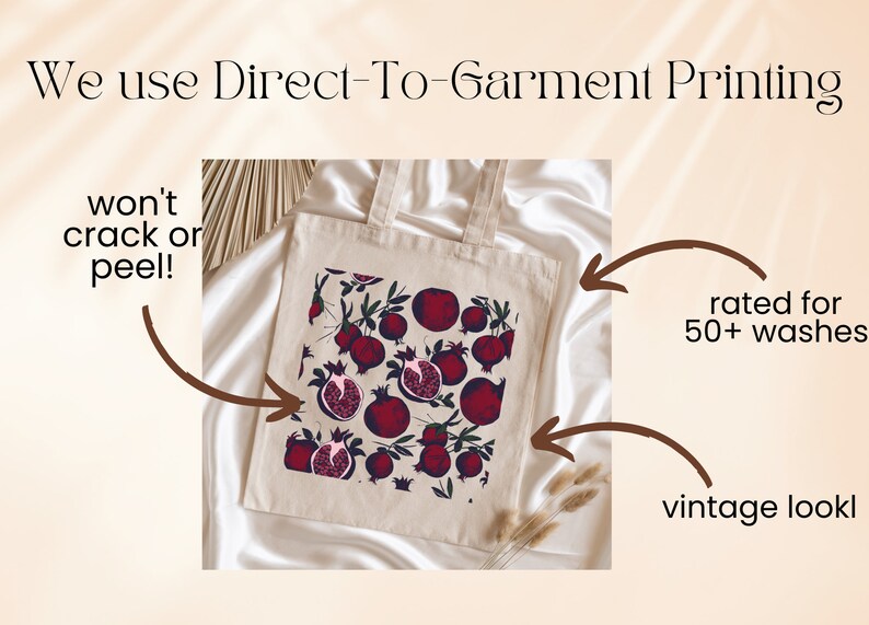 May include: A white tote bag with a red pomegranate print. The bag is made with direct-to-garment printing, which is rated for 50+ washes and has a vintage look.