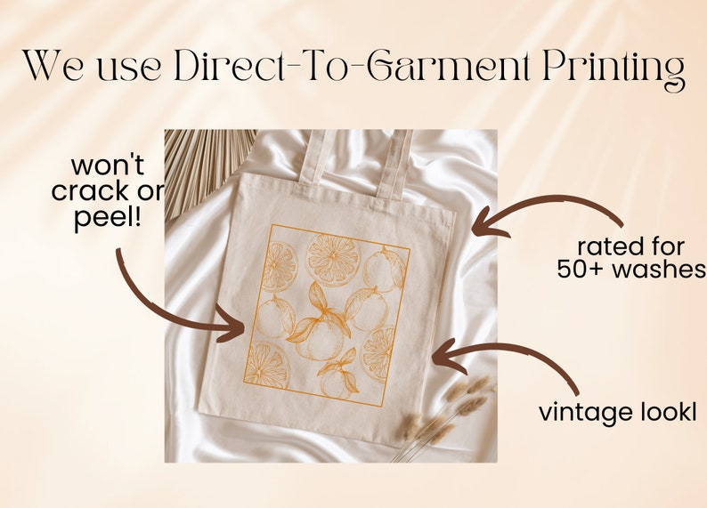 May include: A white tote bag with a design of orange slices and leaves printed in a light orange color. The text "We use Direct-To-Garment Printing" is at the top of the image. The text "won't crack or peel!" is on the left side of the image. The text "rated for 50+ washes" is on the right side of the image. The text "vintage look" is at the bottom right of the image.