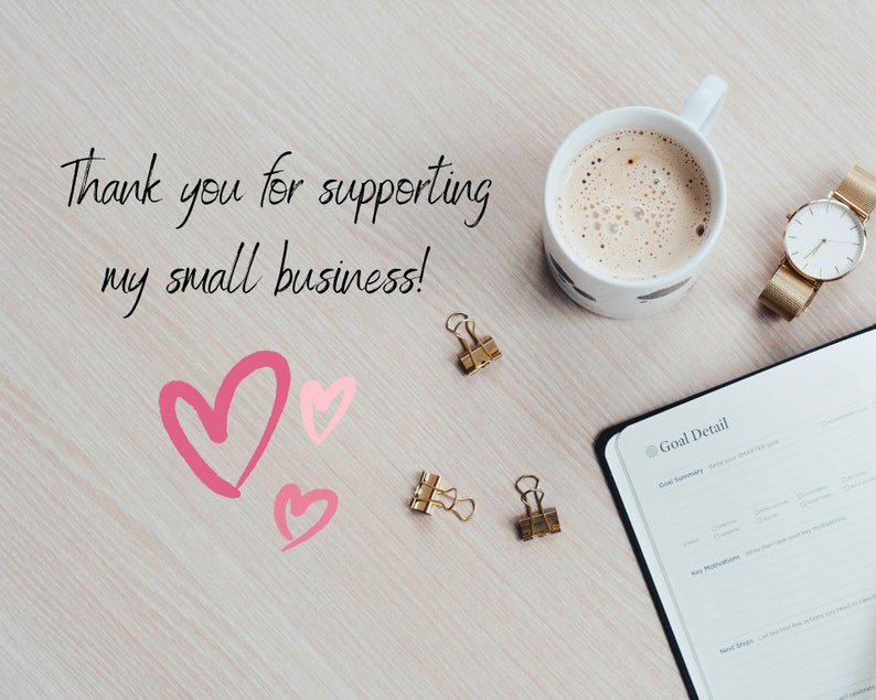 May include: A white coffee mug with a brown liquid inside, a gold watch, two gold paper clips, a pink heart, and a notebook with the text "Goal Detail" on the cover. The text "Thank you for supporting my small business!" is written on a light wood surface.