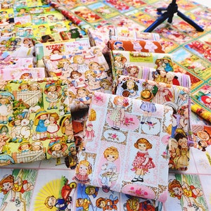 May include: A collection of colourful fabric scraps featuring a repeating pattern of children in various poses. The fabric is printed with a whimsical design of children playing, holding toys, and wearing different outfits. The fabric is perfect for crafting projects, quilting, and scrapbooking.