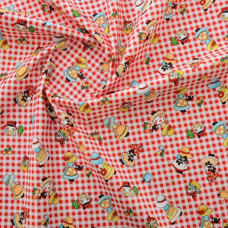 May include: Red and white gingham fabric with a repeating pattern of small girls wearing red dresses and white hats. The girls are holding baskets of flowers and watering cans. There are also small houses and flowers scattered throughout the pattern.