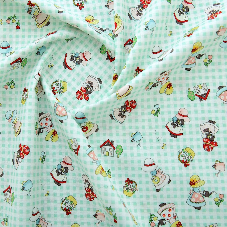 May include: A green and white checkered fabric with a repeating pattern of black and white figures wearing hats and holding baskets of flowers. The figures are surrounded by small green flowers, watering cans, and houses.