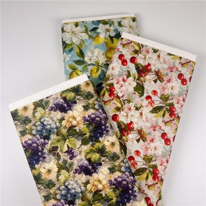 May include: Three rolls of decorative paper with floral and fruit patterns. One roll features grapes, another cherries, and the third lemons and white flowers. Each roll has a white band at the top.