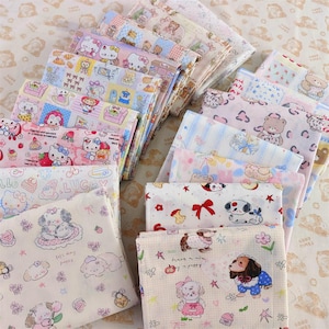 Puede incluir: Una colección de cuadrados de tela doblados con varios estampados de personajes de dibujos animados, incluyendo osos, perros y Hello Kitty. Las telas presentan colores pastel como rosa, azul y amarillo, con patrones repetidos de los personajes y otros elementos decorativos.