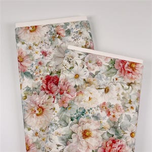 May include: Two rolls of floral fabric featuring a watercolor design. The fabric displays large, detailed flowers in shades of pink, red, and white, with green and blue foliage against a cream background. The rolls have a white border.