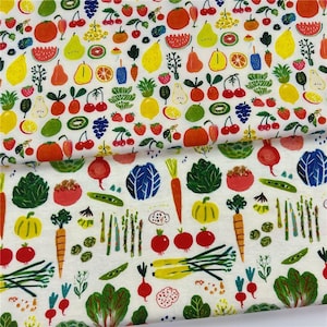Peut inclure: Tissu blanc avec un motif coloré de fruits et de légumes. Le motif comprend des illustrations de cerises, de fraises, de citrons, d'oranges, de carottes et de choux. Le tissu est probablement en coton ou dans une matière similaire.