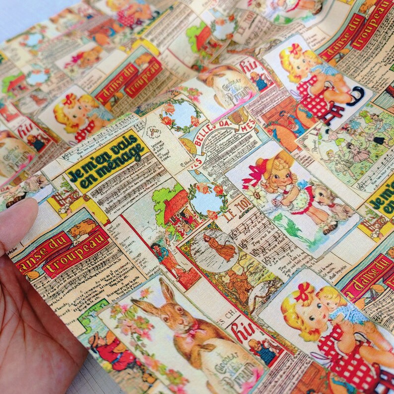 May include: A colorful fabric with a repeating pattern of vintage illustrations. The illustrations include a rabbit, a girl in a red dress, and a musical score. The fabric is printed with French text, including "Je m'en vais en menage" and "Le Mon."