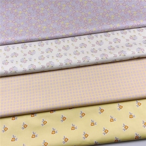 May include: Four fabric swatches in pastel colors. The top swatch is lavender with a floral pattern in pink and yellow. The second is white with pink and blue flowers. The third is a light yellow grid pattern. The bottom swatch is yellow with orange flowers.